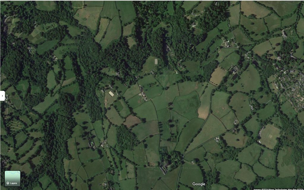 A diverse agricultural landscape west of Chagford, Dartmoor, Devon, England with woodlands, farm fields and many hedgerows. Google Maps satellite view. 